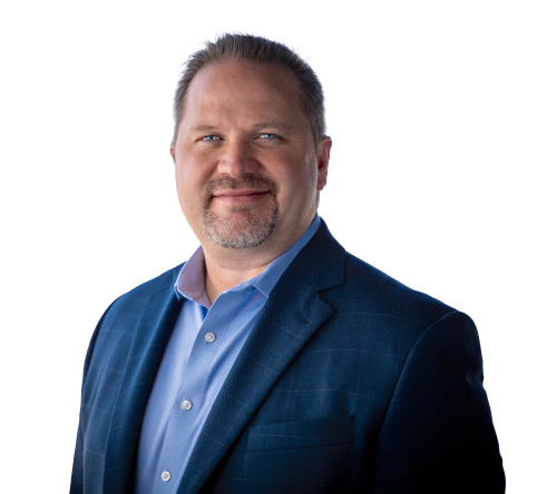 Man with short gray hair and beard, wearing a blue blazer over a light blue shirt, smiling.