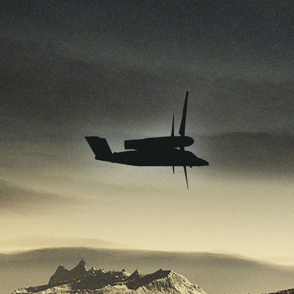 Silhouette of a helicopter flying above mountainous terrain against a twilight sky.