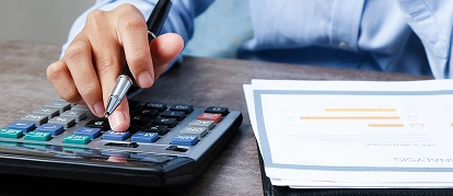 Project manager calculating cost estimates with a calculator