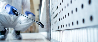 Worker in a hard hat, spraying an interior wall