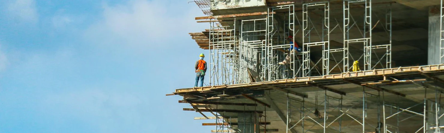 Workers on scaffolding at a multi-story commercial building under construction