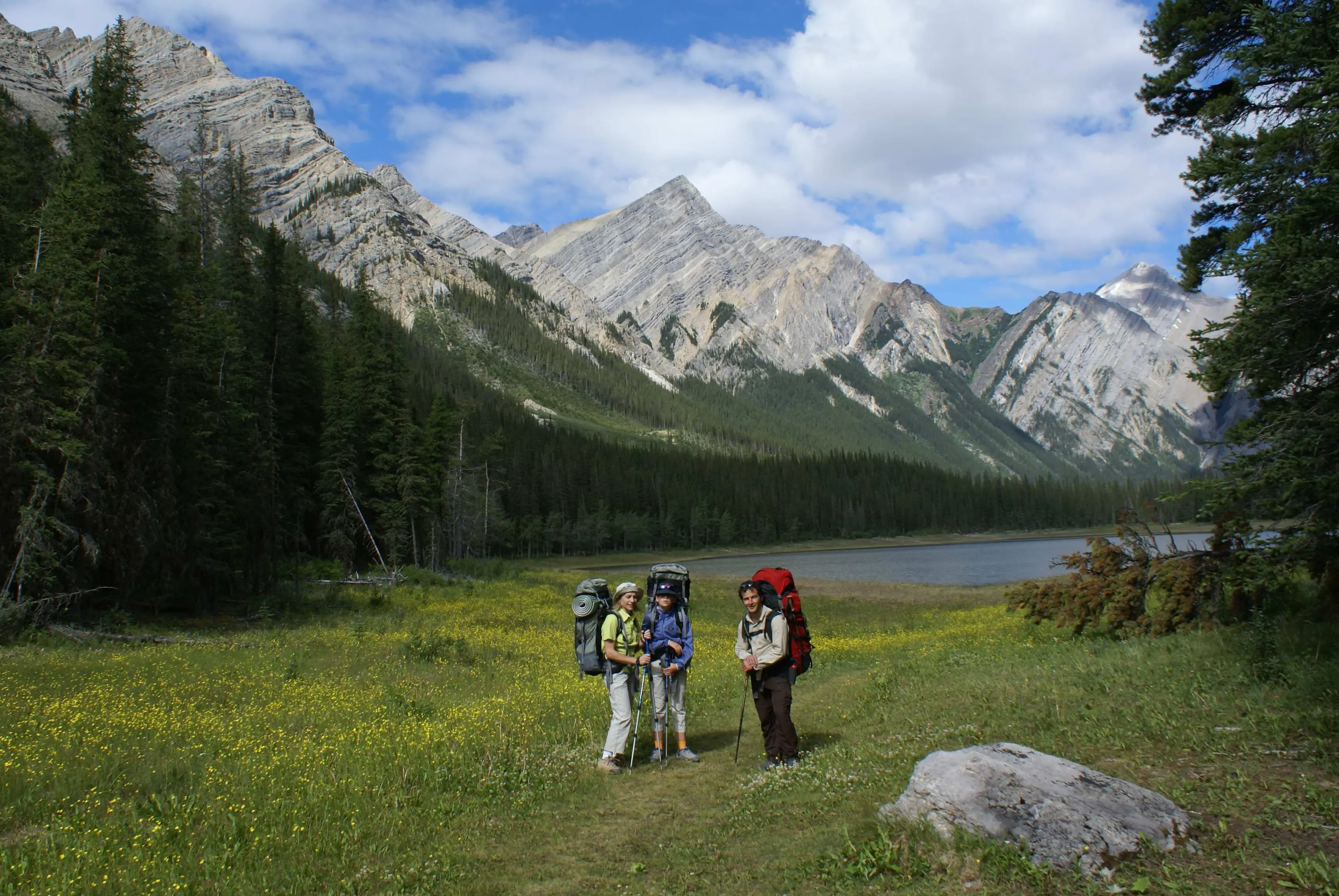 Backpackers hiking near a mountain lake in Jasper National Park