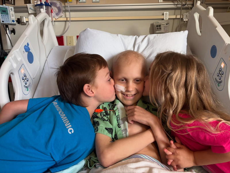 Dominic in his hospital bed with his siblings