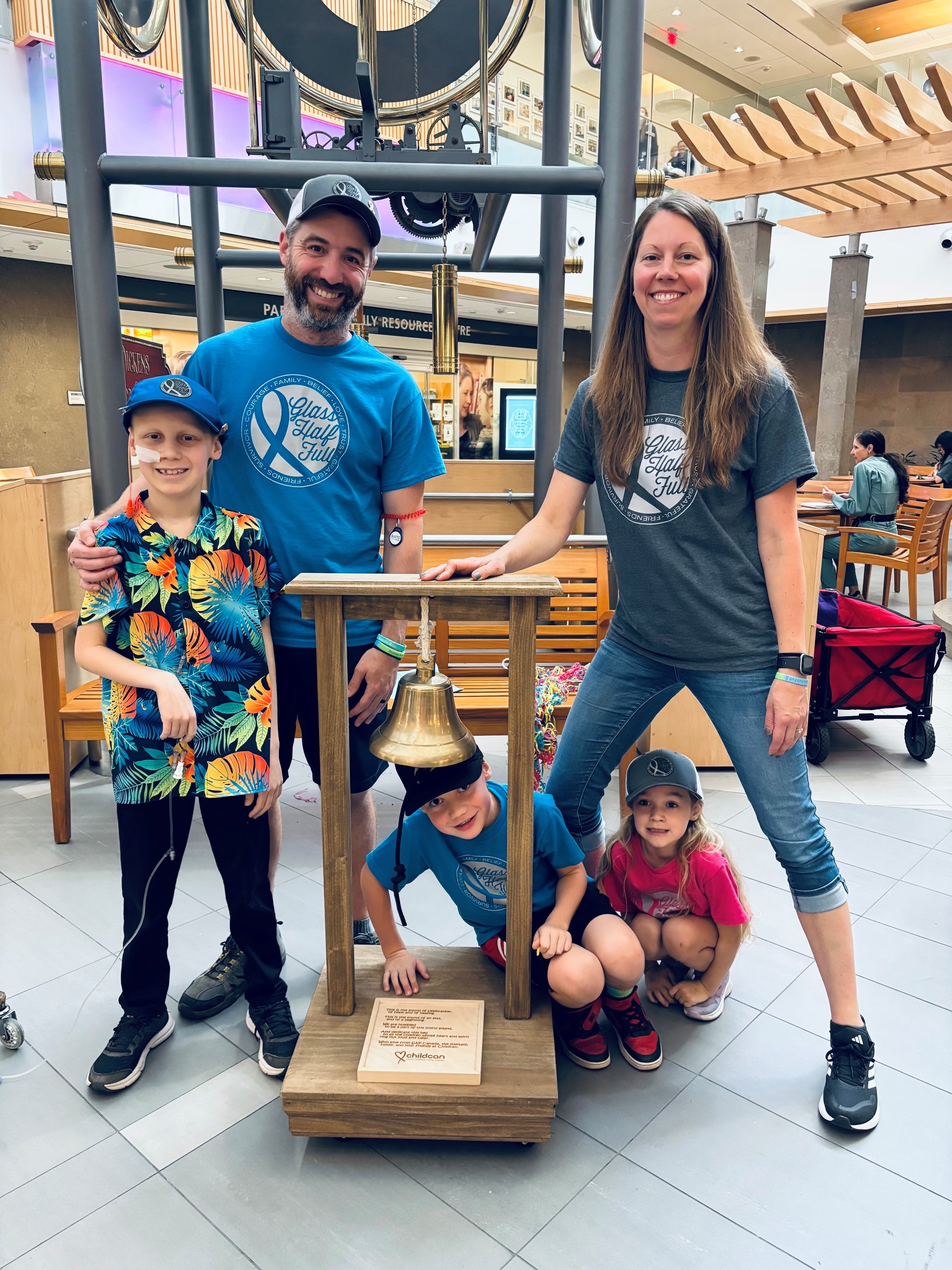 Dominic rings the bell to mark the end of treatment with his family