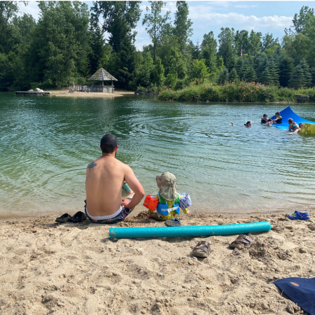 Father and son sit by a lake
