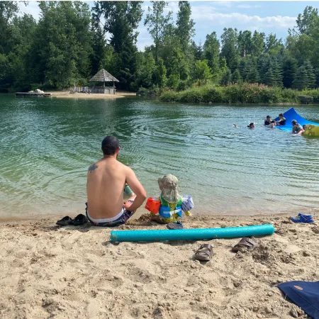 Father and son sit by a lake
