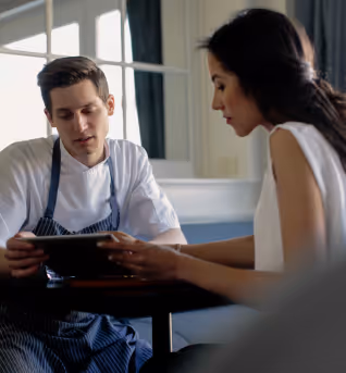 Beratungsgespräch zwischen Gastronom und Versicherungsexperte