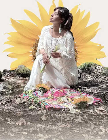 Woman in white dress sitting on colorful cloth on forest ground holding a white flower, with a large sunflower digitally placed behind her.