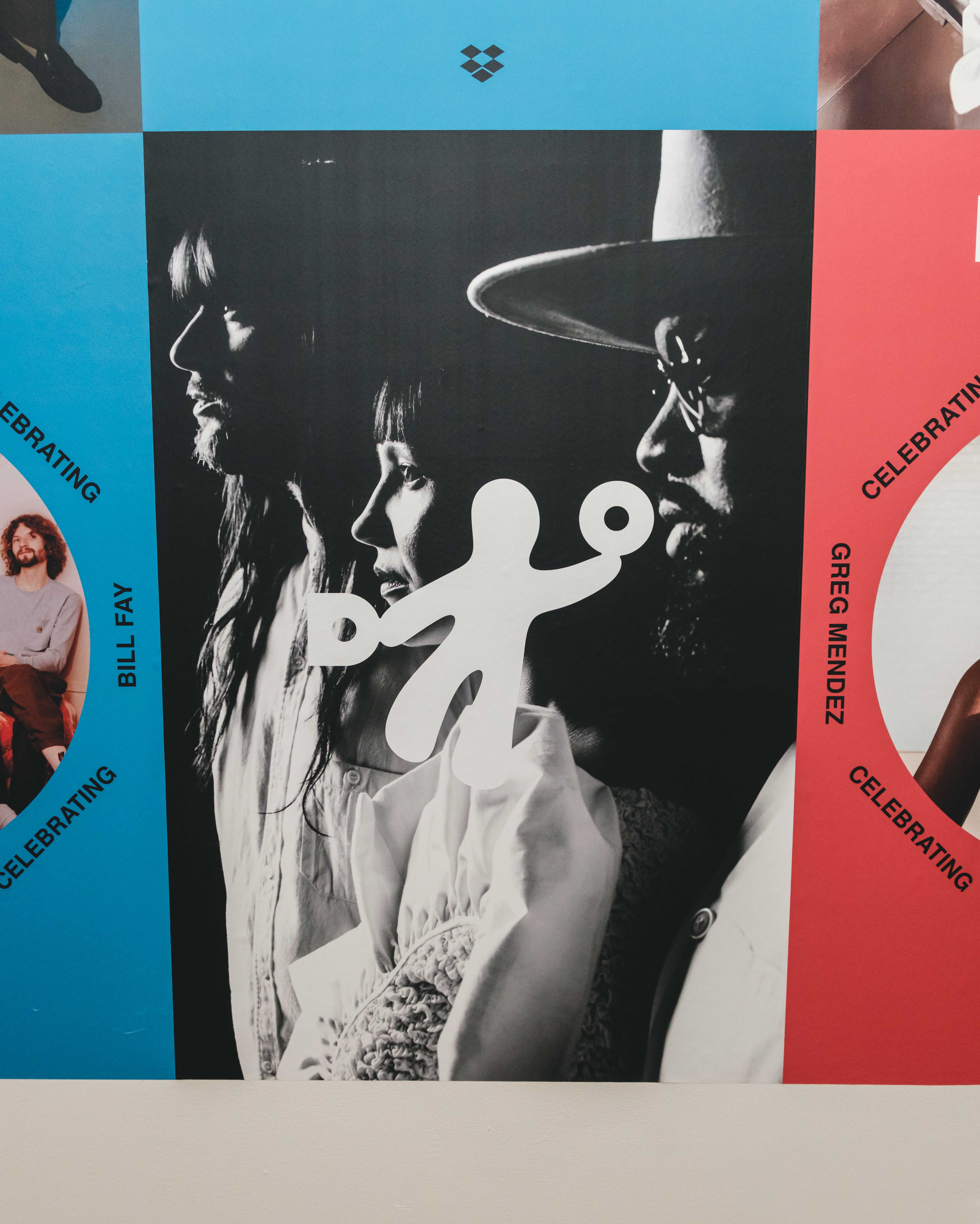 Photo of a colorful event display featuring a black-and-white portrait of two people in profile, overlaid with a white Dropbox-style icon