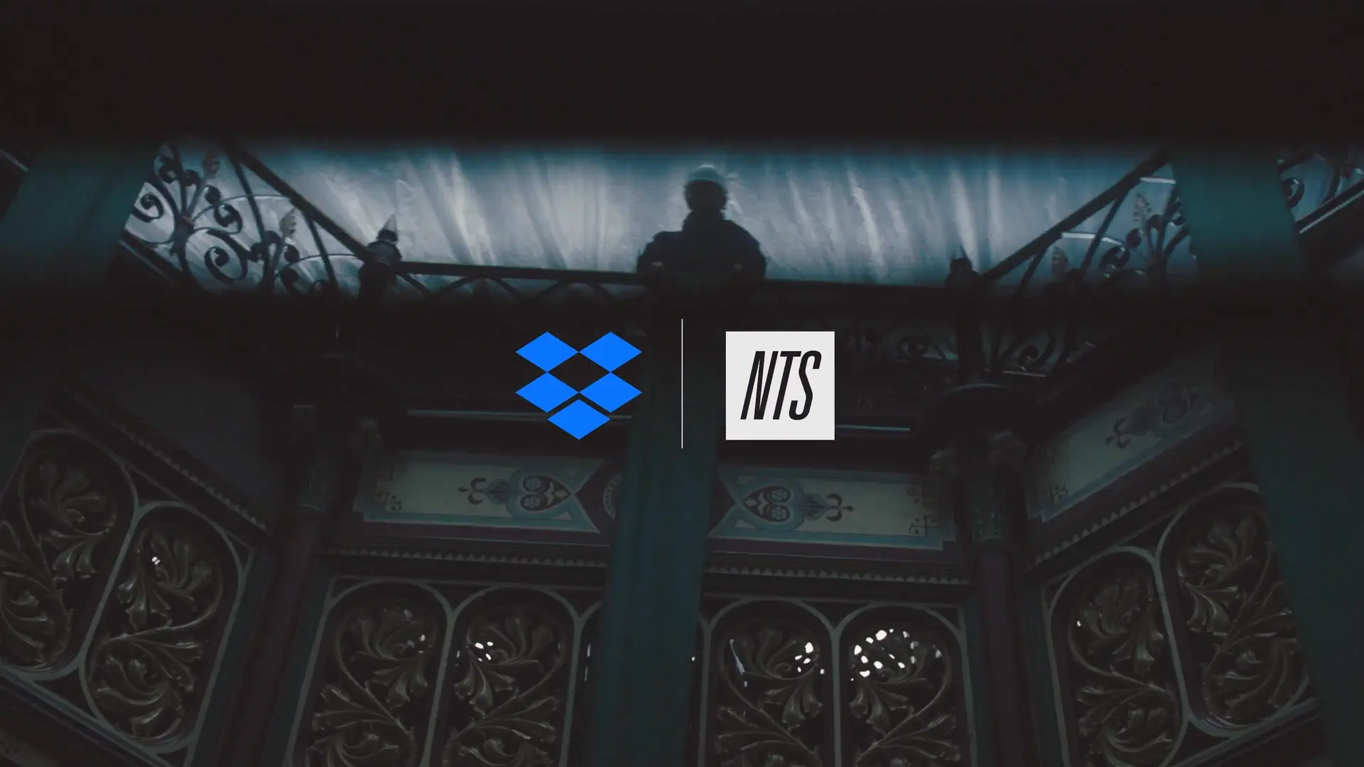 Dropbox and NTS logos over a dark, ornate interior with a silhouetted figure above.