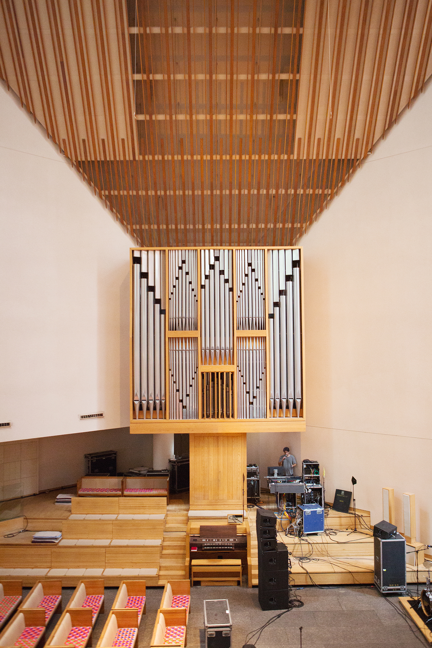 Pipe organ at front of a modern church or concert hall interior.
