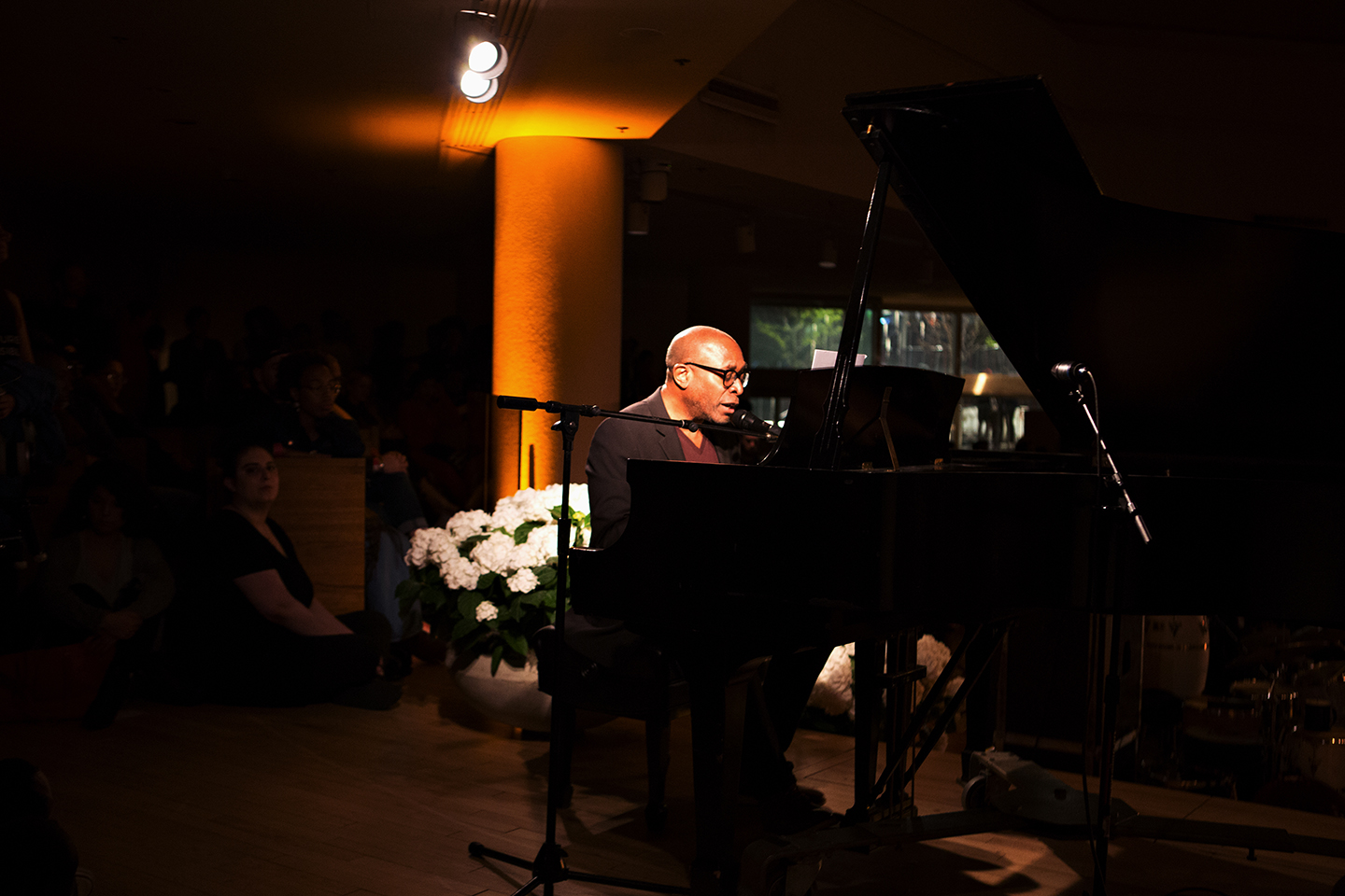 - Pianist performing at a grand piano in a dimly lit indoor venue.