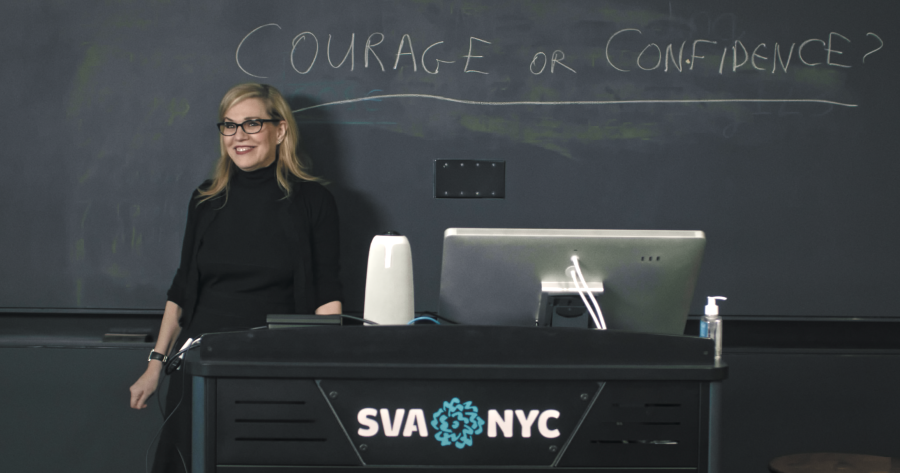 Woman standing at podium before chalkboard reading “Courage or Confidence?”