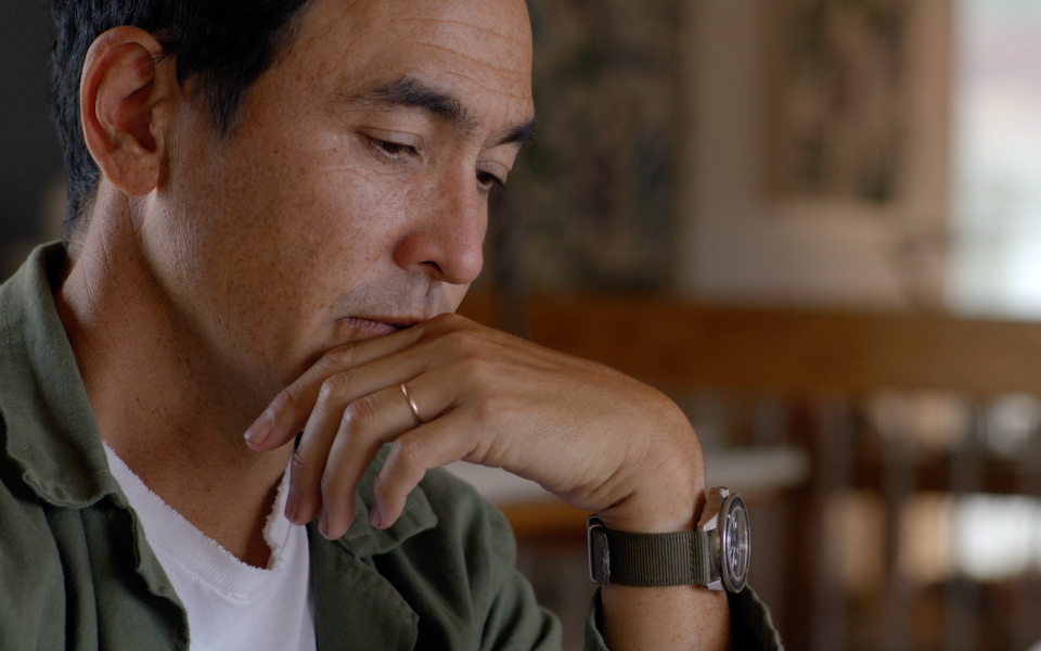 - Close-up of a thoughtful man resting his hand on his chin indoors.
