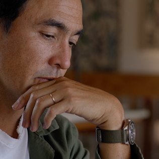 Close-up of a thoughtful man resting his hand on his chin indoors.