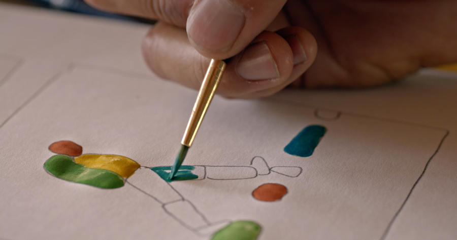 Hand painting colorful abstract shapes on a sketch with a fine brush.