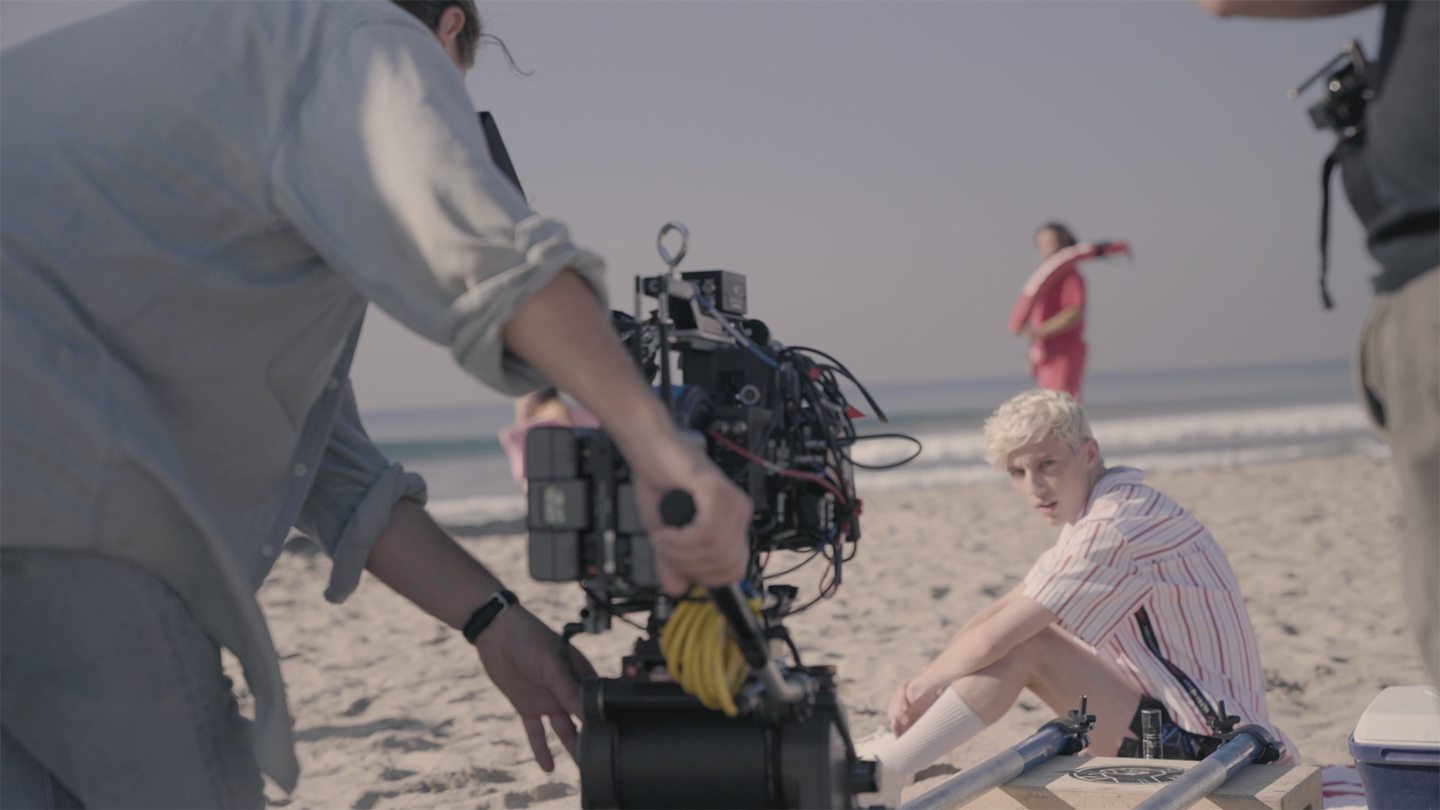 Film crew shooting a beach scene with actor