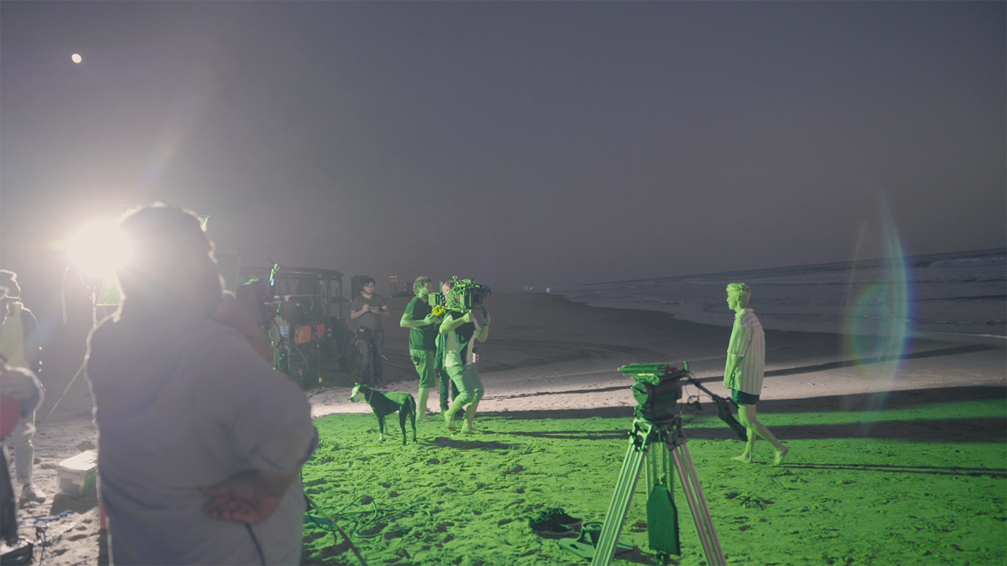 Film crew shooting on a beach at night.