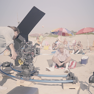 Film crew shooting on a sunny beach.