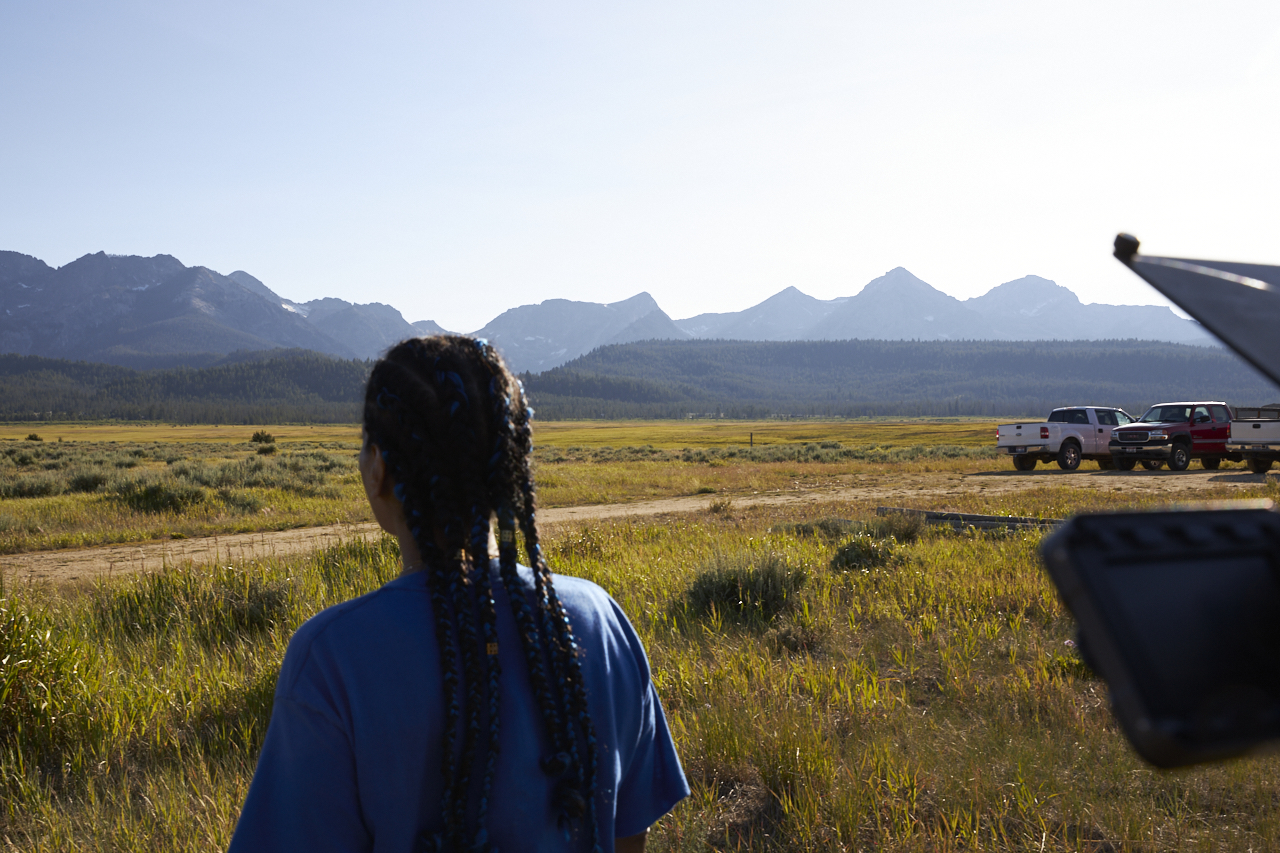 Person looks toward mountains in a field