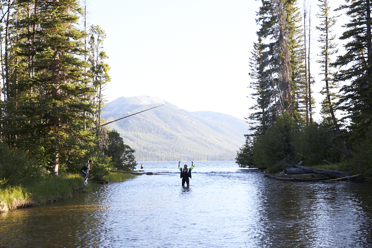 People wading in a mountain lake