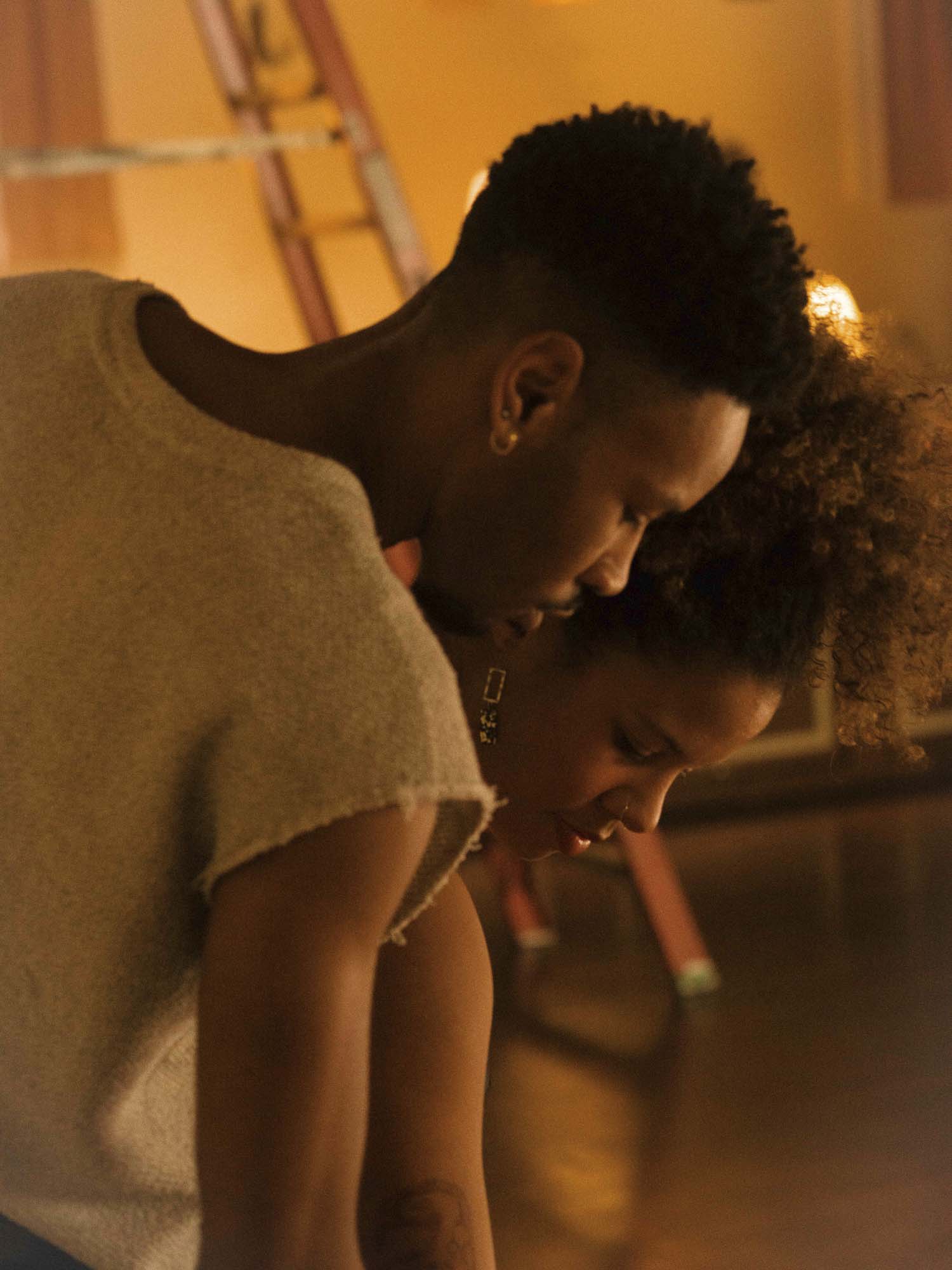  - Two people lean over equipment during production setup