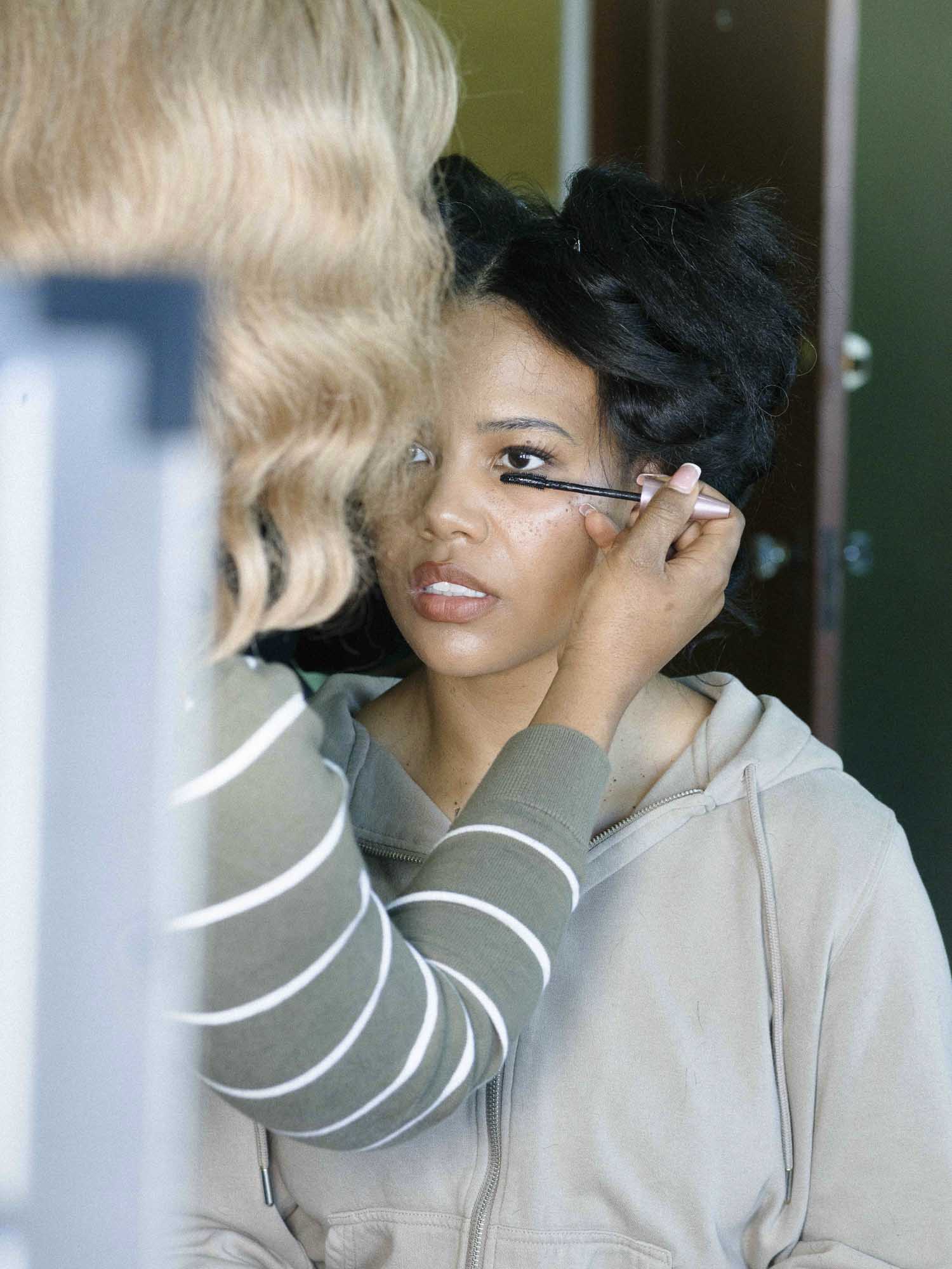 Makeup artist applies mascara to Baby Rose