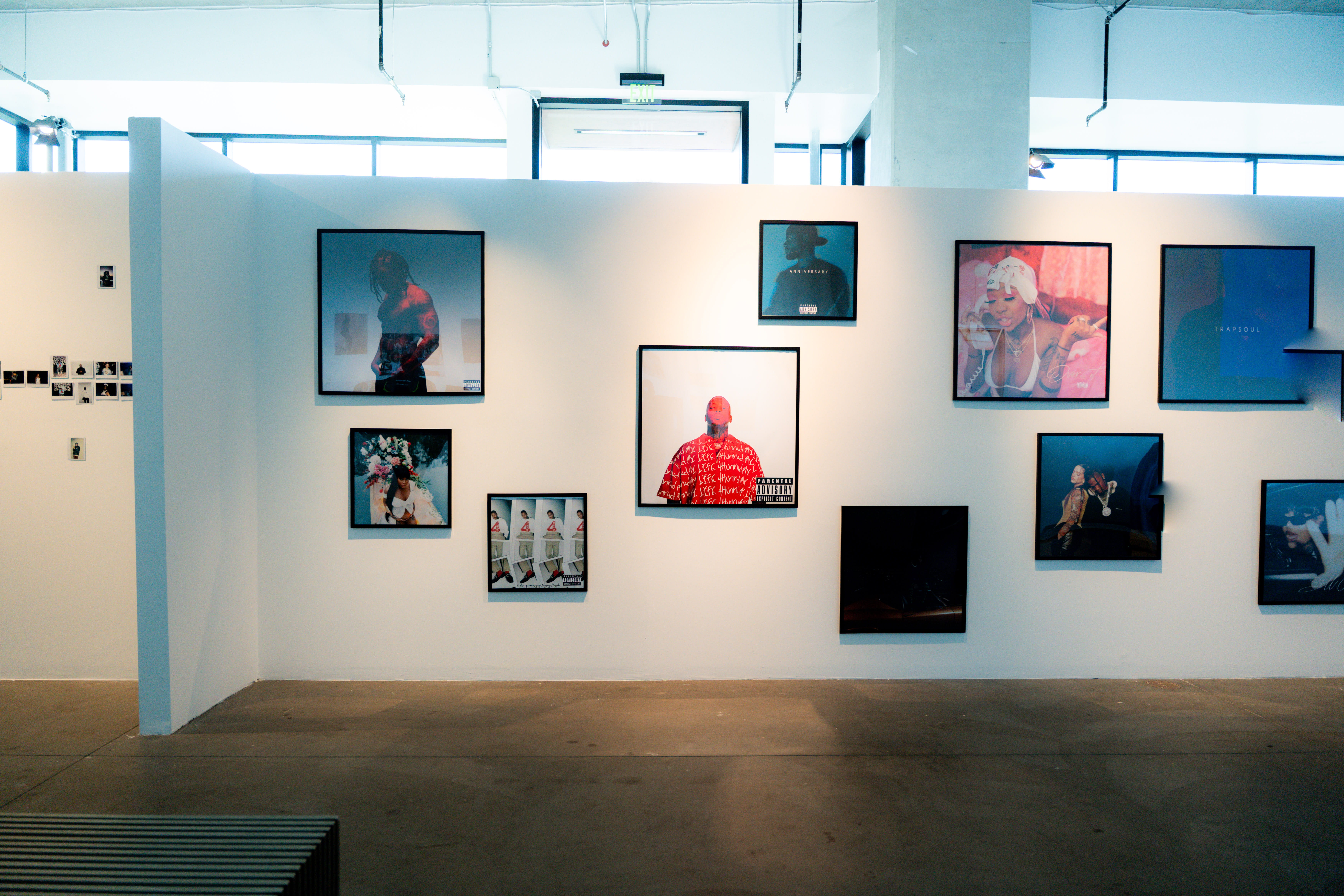 Gallery wall displays framed album artwork and portraits in exhibition space