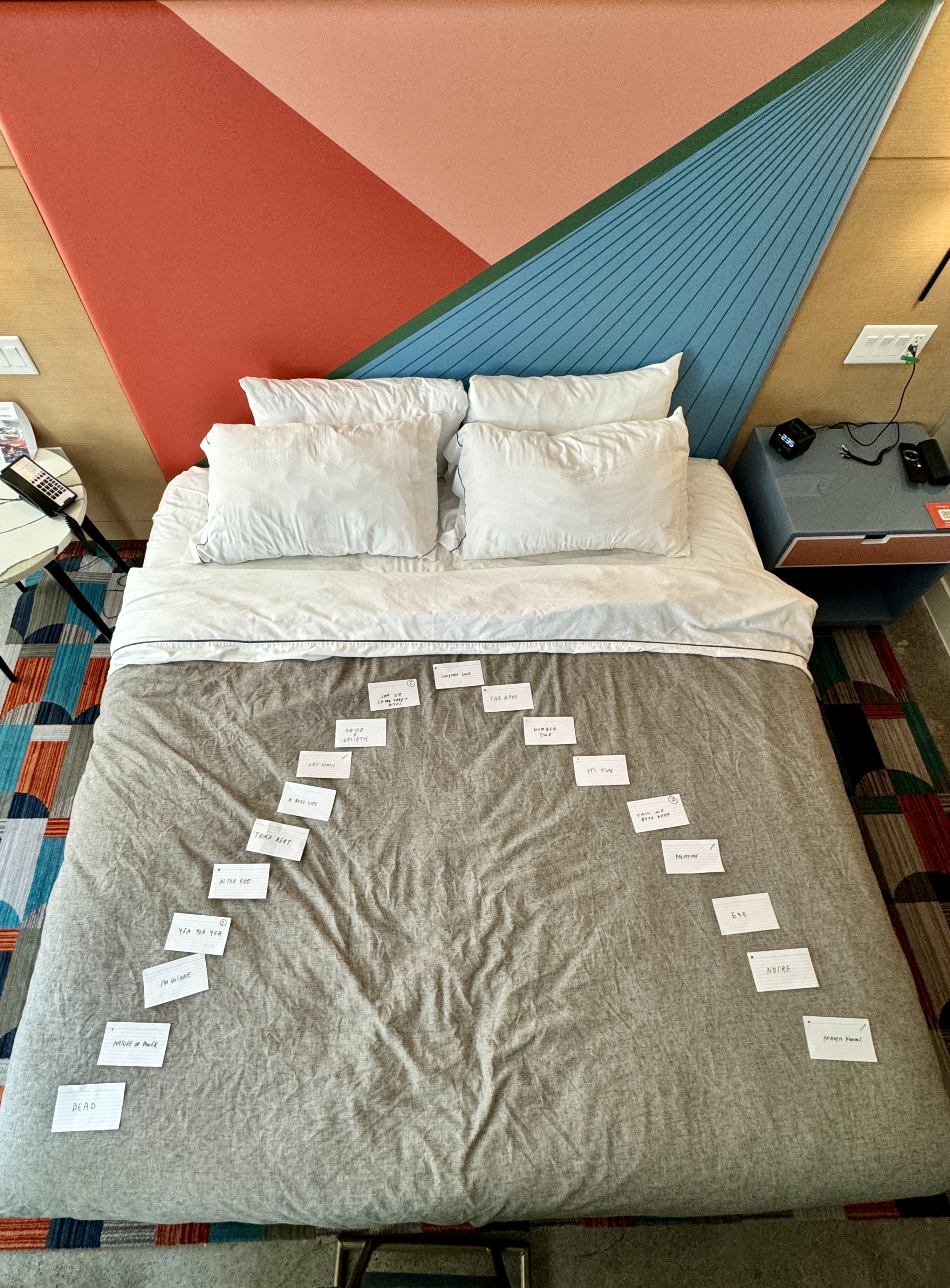 - Bed covered with handwritten note cards arranged in a wide arc