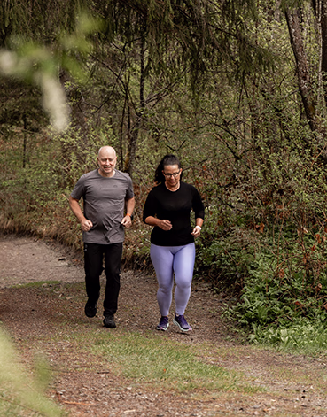 2 Menschen joggen im Wald