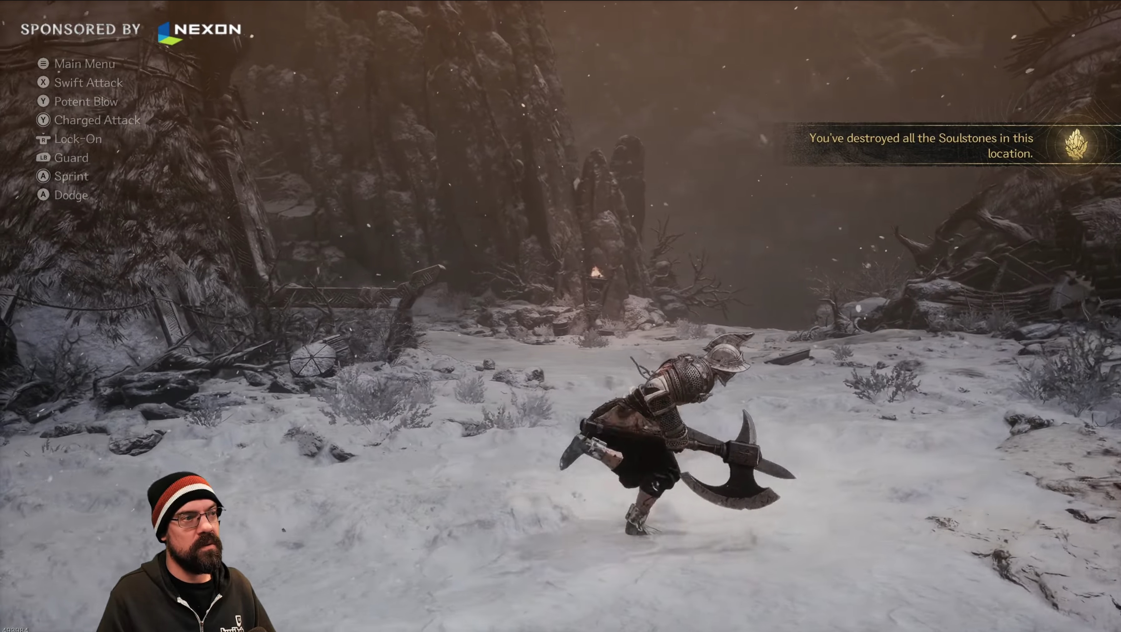 Video game scene of an armored character wielding a large axe in a snowy, rocky environment with game controls and a notification stating all Soulstones are destroyed.