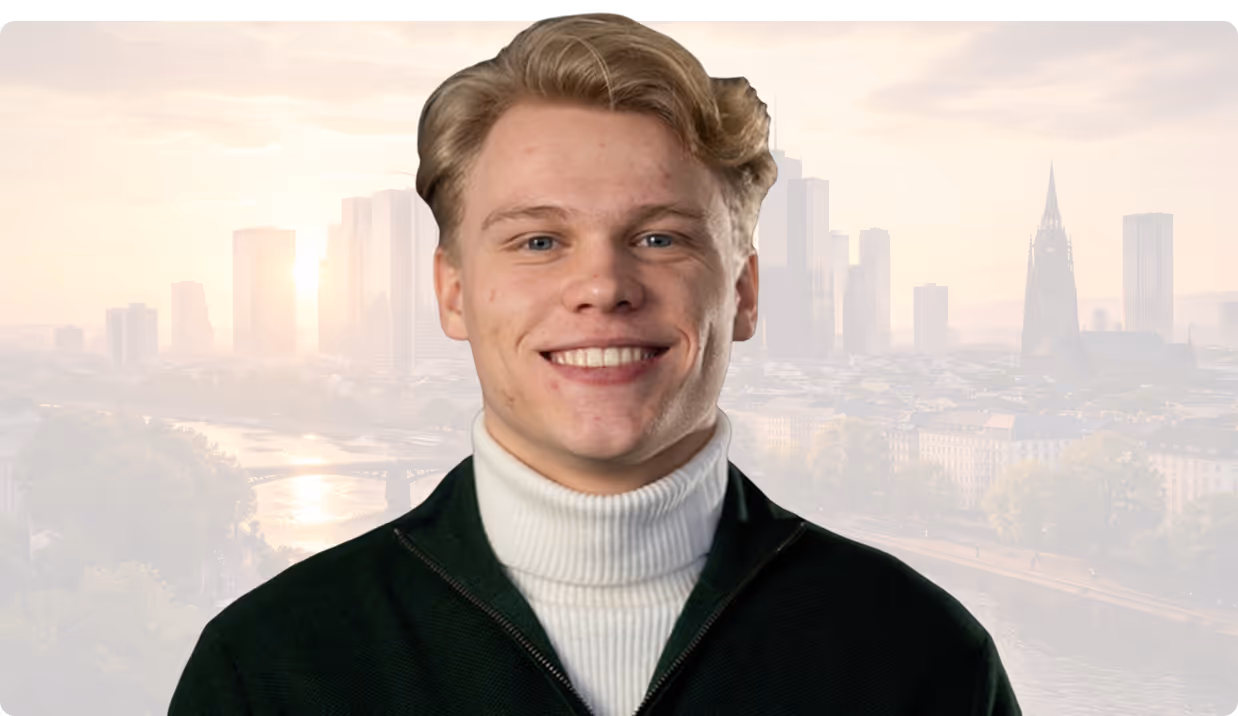 Junger Mann mit hellem Haar, weißem Rollkragenpullover und schwarzem Pullover vor einer Stadtansicht.
