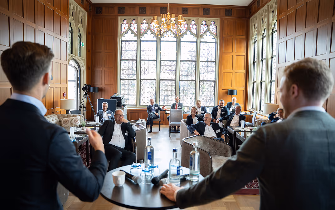 Gruppenfoto von 16 jungen Erwachsenen, die in einem Klassenraum vor einer weißen Tafel stehen.