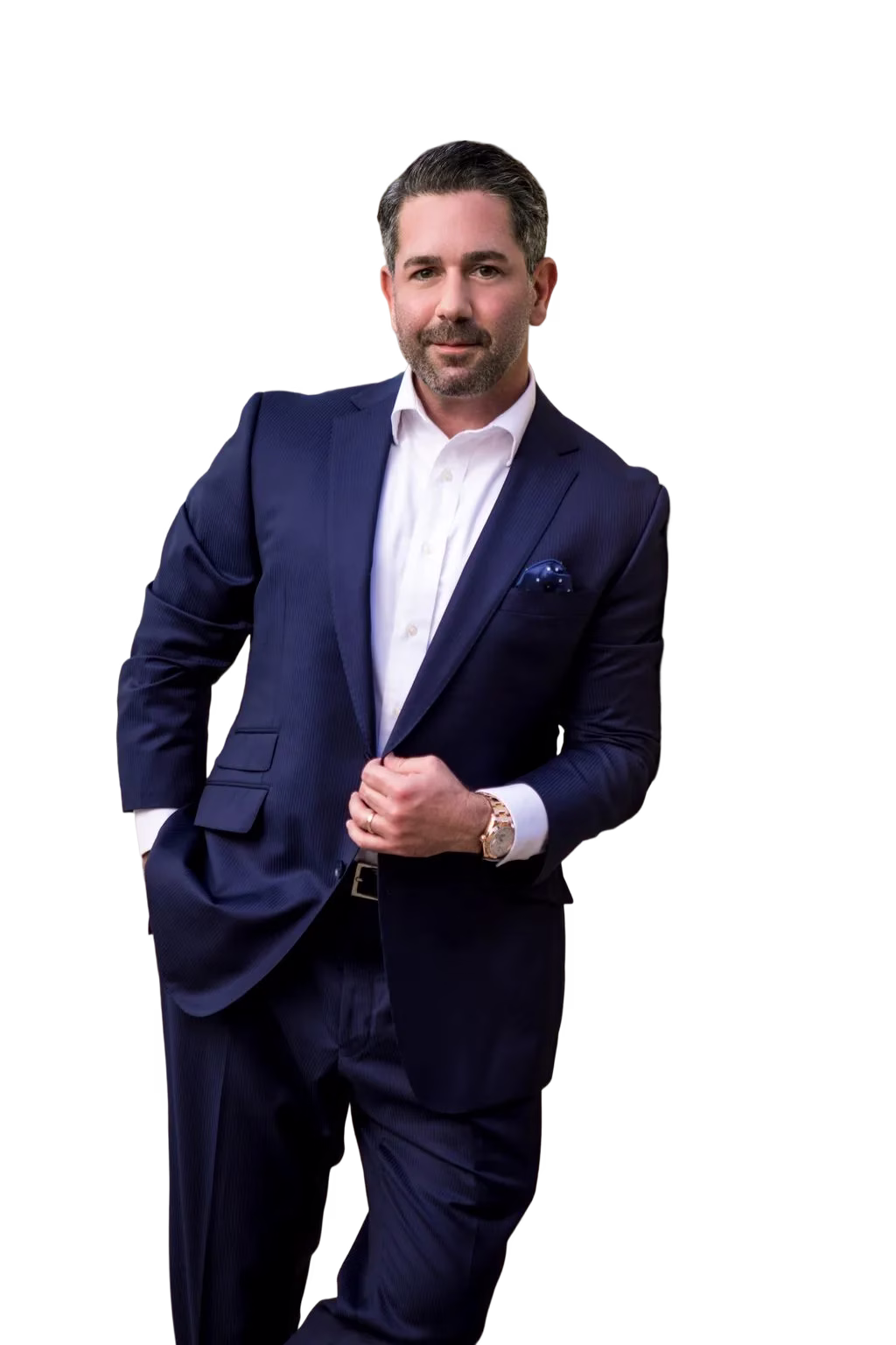 Man in navy blue suit with white shirt and watch, posing against black background.