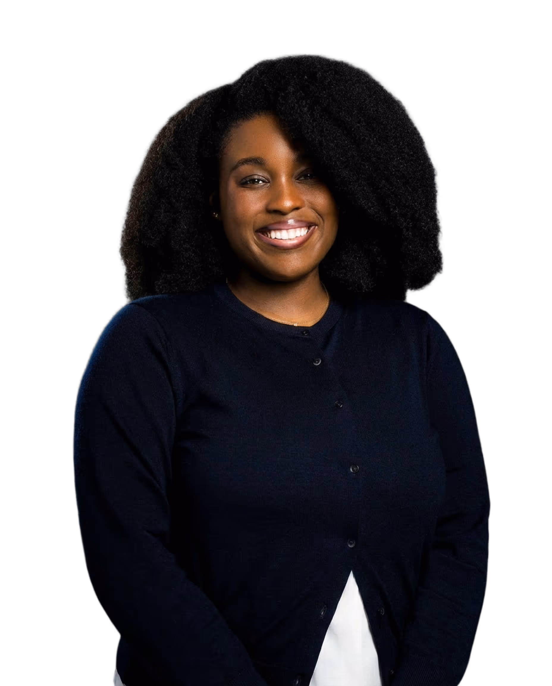 Smiling woman with voluminous curly hair wearing a dark navy cardigan over a white top.