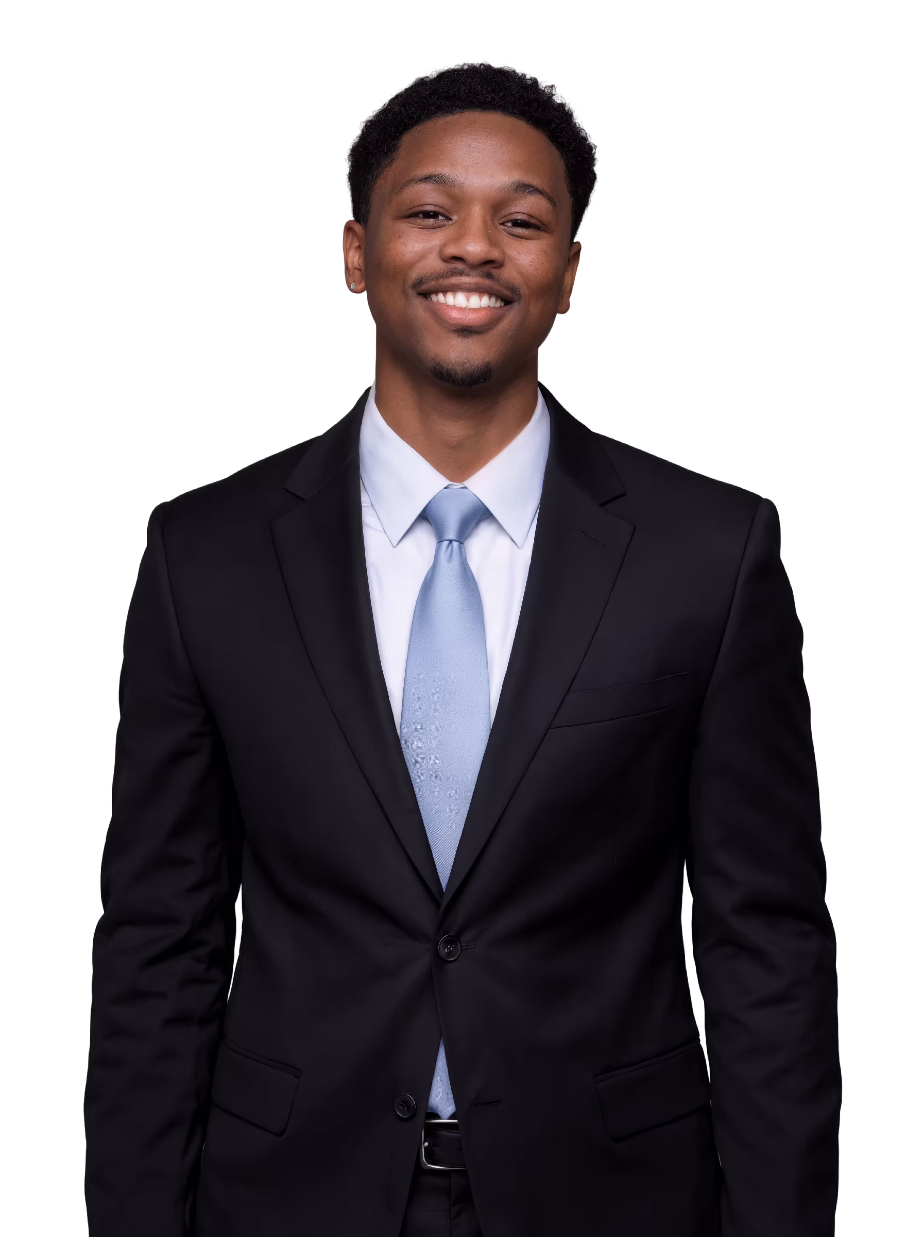 Smiling young man wearing a black suit and light blue tie against a black background.