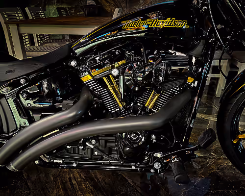 Close-up of a black Harley-Davidson motorcycle engine with shiny chrome parts and exhaust pipes.