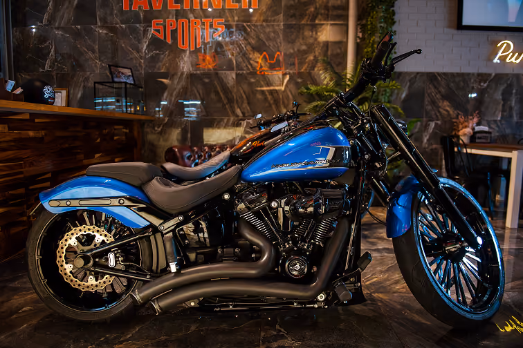 Blue and black Harley-Davidson motorcycle parked indoors with polished floor and decor background.