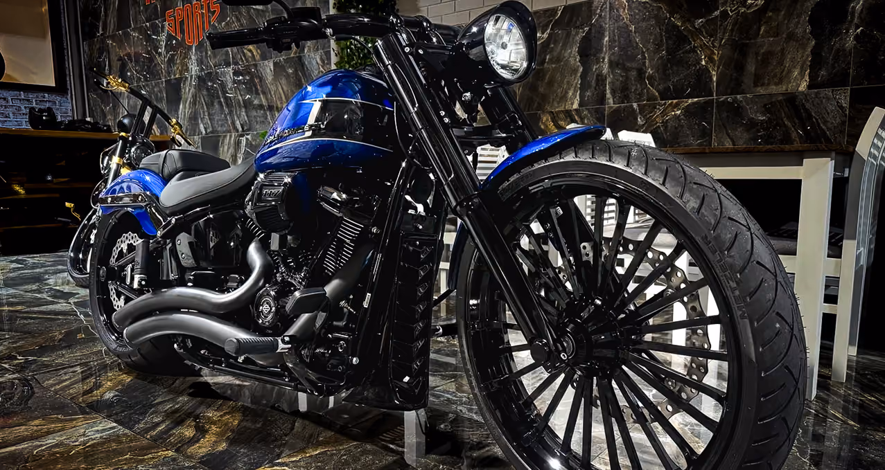 Close-up of a black and blue motorcycle with large front wheel inside a showroom.