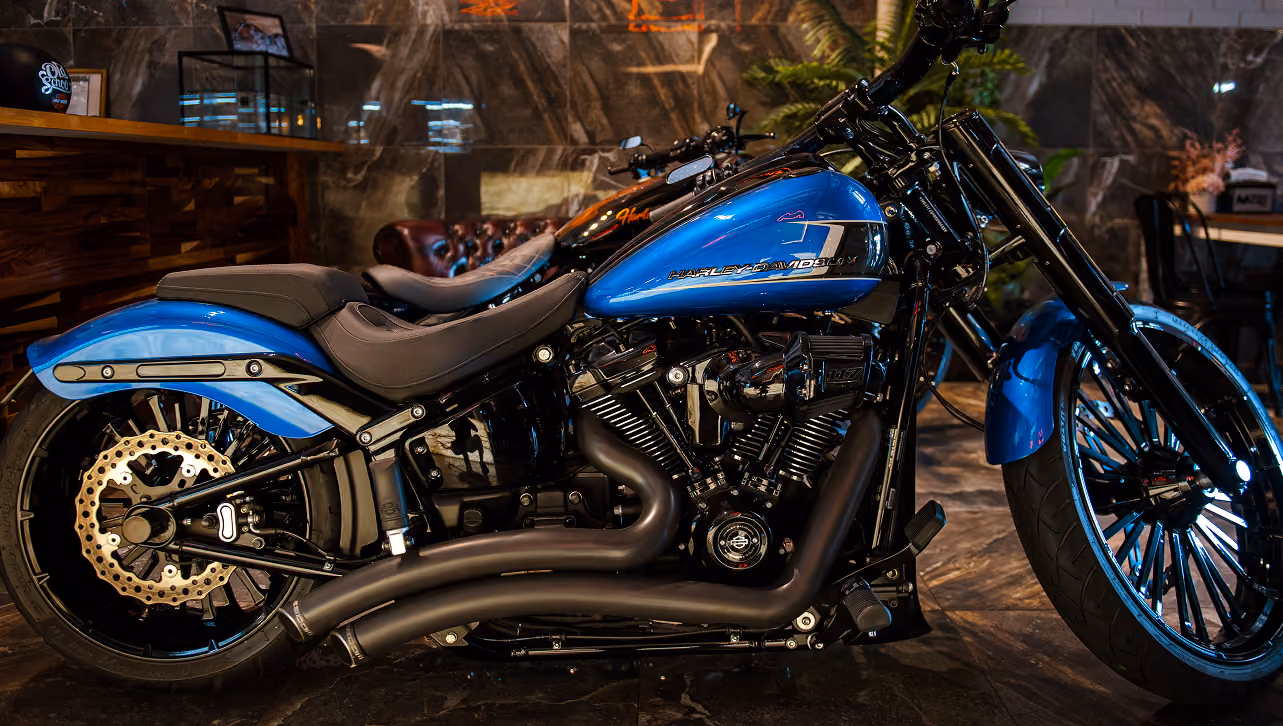 Blue and black Harley-Davidson motorcycle parked indoors with polished surfaces and stylish design.