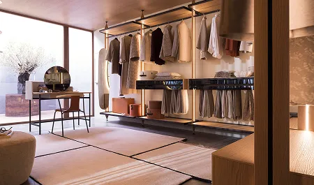 Dressing moderne avec vêtements suspendus, table avec miroir rond, chaise et grande fenêtre laissant entrer la lumière naturelle.