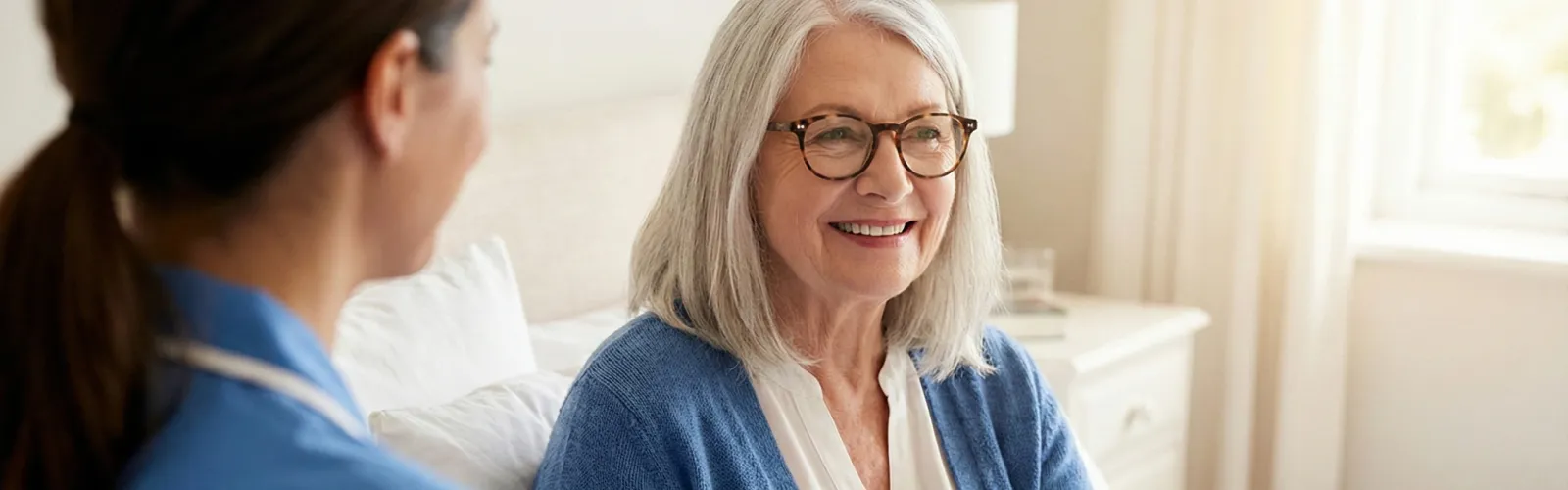 Pflegefachkraft von confido Care zeigt Patientin Informationen auf einem Tablet zur ambulanten Antibiotikatherapie