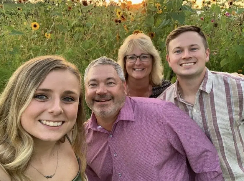 Craig Storck with his family in a sunflower field at sunset