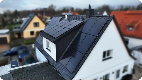 Bright modern kitchen with light wood cabinets, white countertops, and large glass doors opening to a green outdoor area.