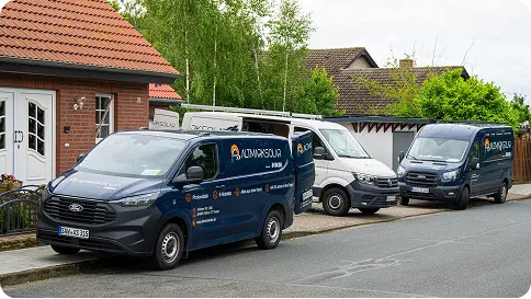 Person with a bun hairstyle and glasses facing away, wearing a striped shirt in sunlight.