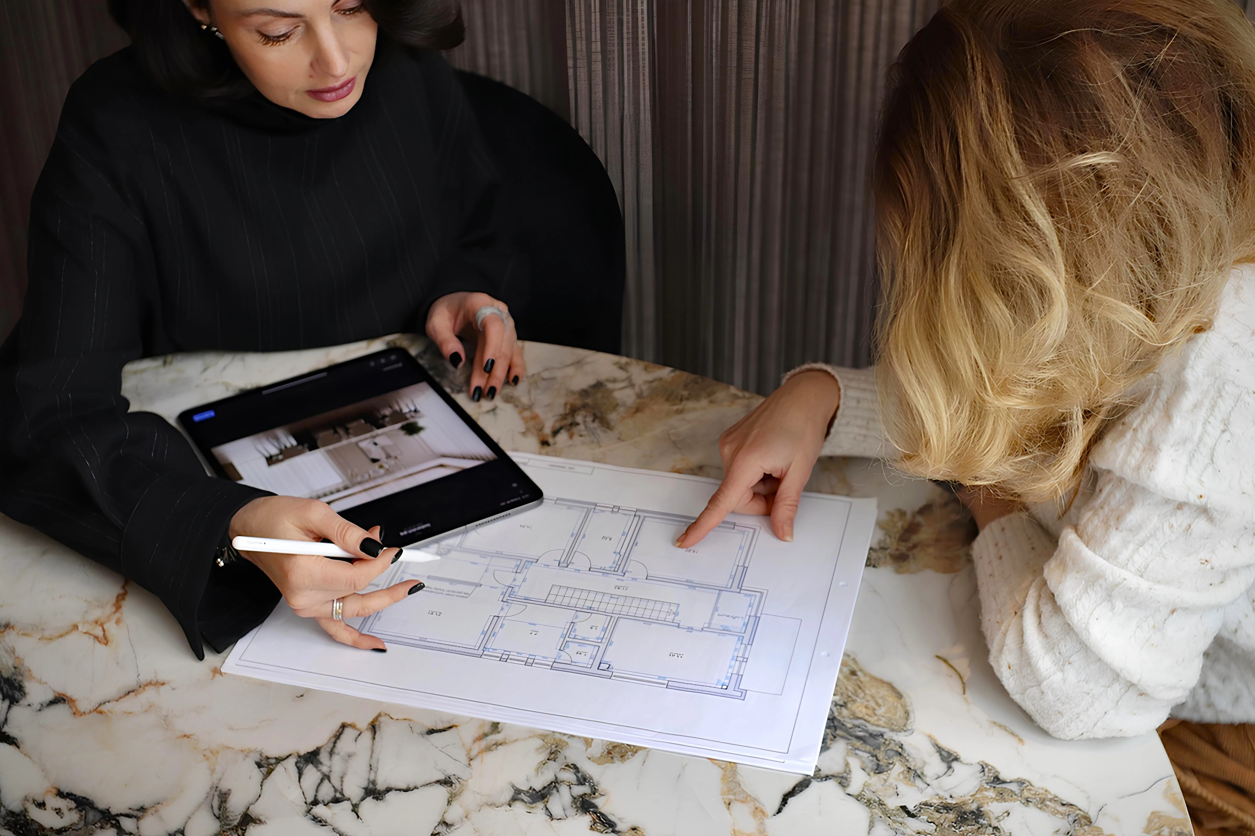 Interior Designerin bespricht Grundrissplan mit Kundin beim Erstgespräch – Studio Menash Berlin