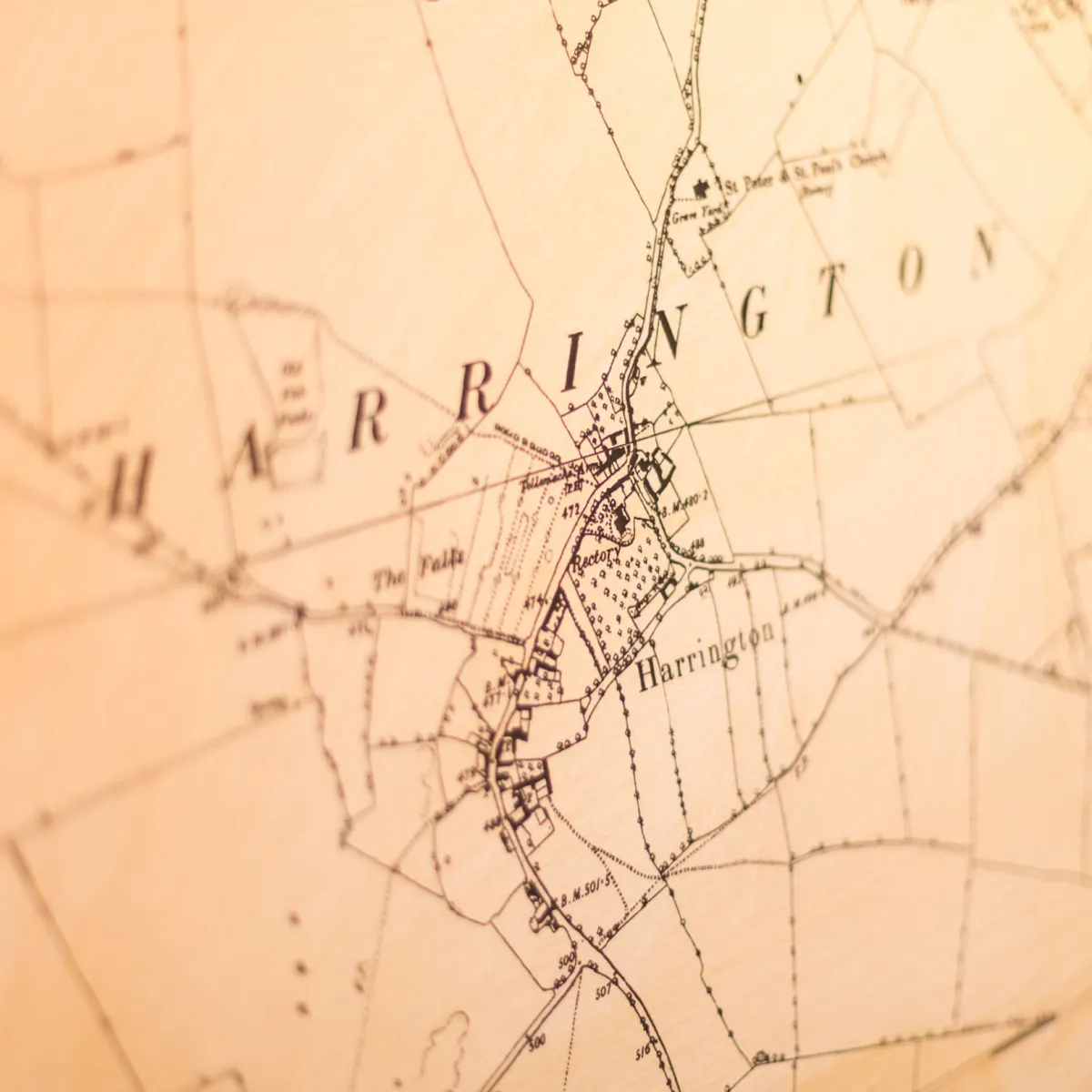 Close-up of an old, sepia-toned map showing the area labeled Harrington with roads, fields, and buildings.