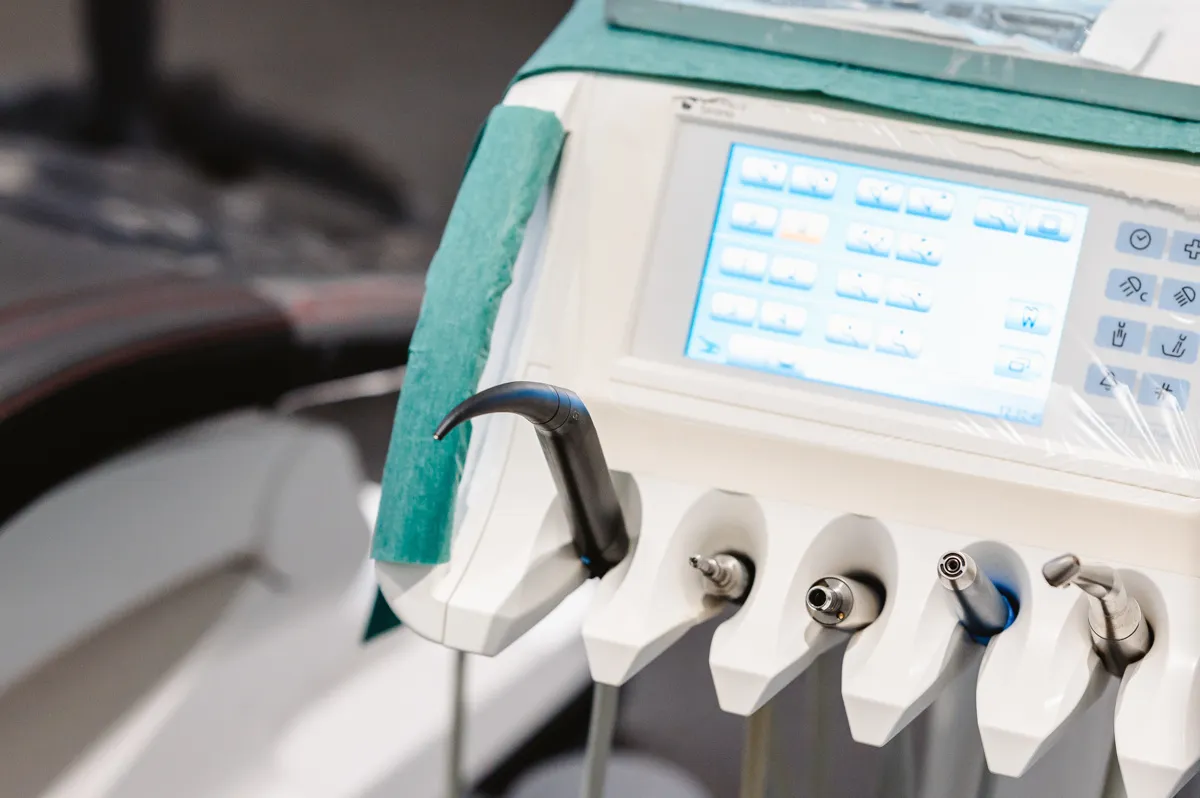Dental equipment control panel with multiple handpieces and a digital display screen.