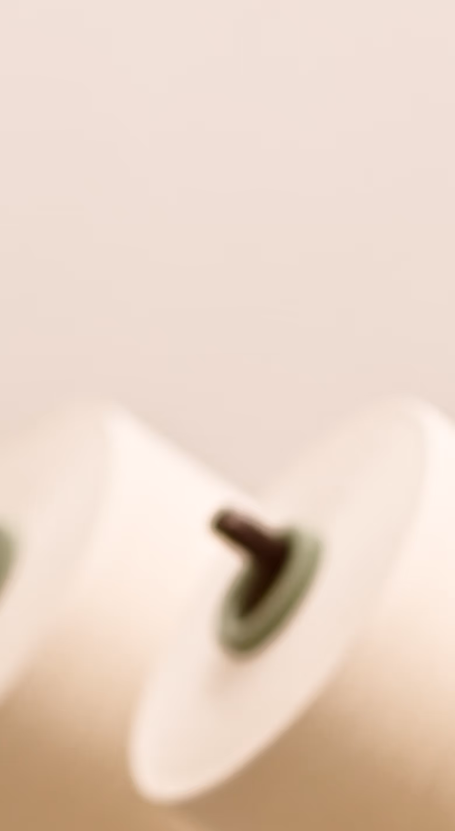 Close-up of a white electric guitar tuning peg with a blurred background.