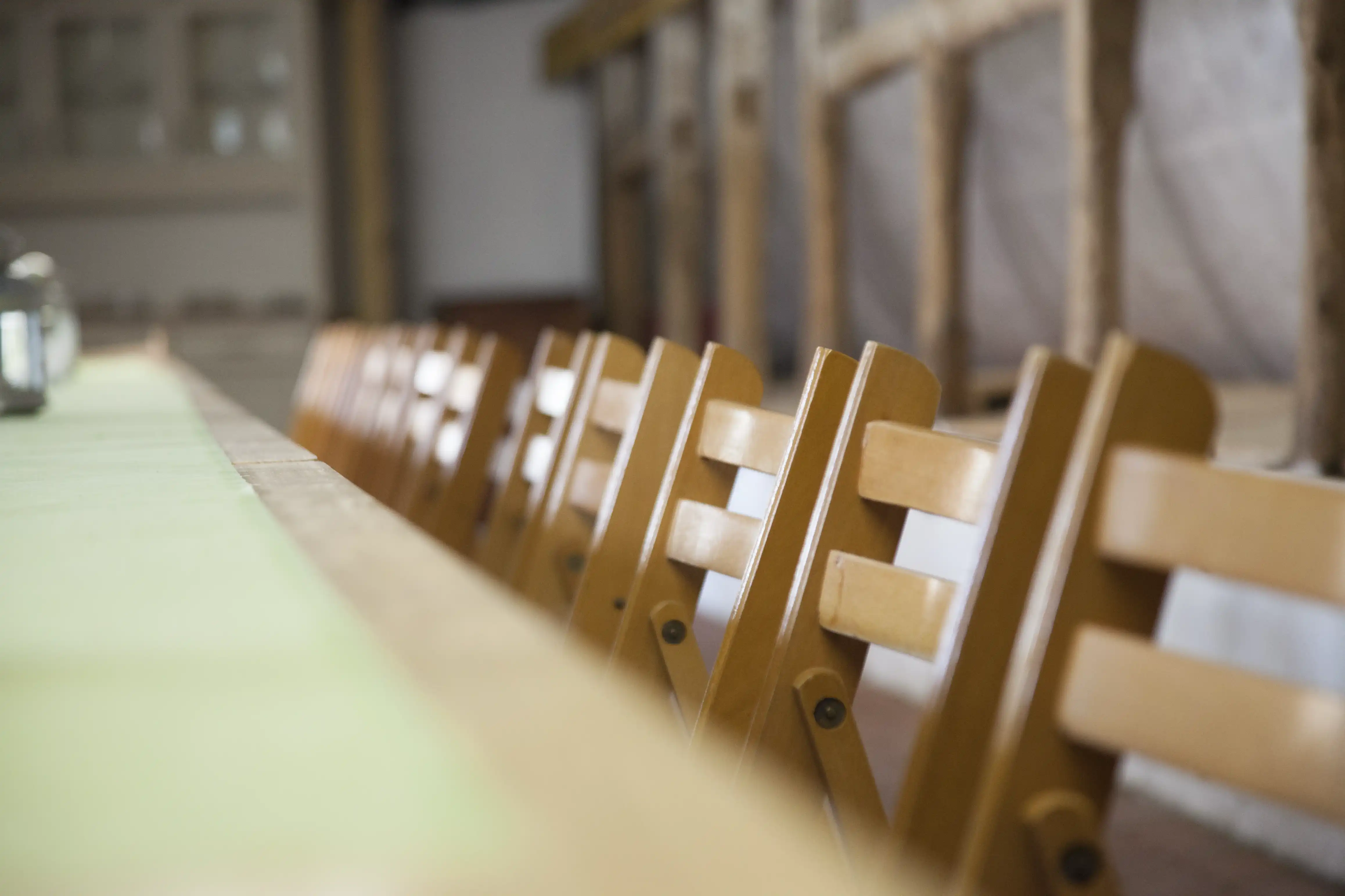 Detailansicht der Bestuhlung im historischen Stall des Lorf B&B Aken, Holzstühle für Bankette und Veranstaltungen.